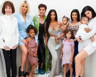 A group photo of the Kardashian-Jenner family, including children, posing together on a white background.