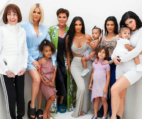 A group photo of the Kardashian-Jenner family, including children, posing together on a white background.