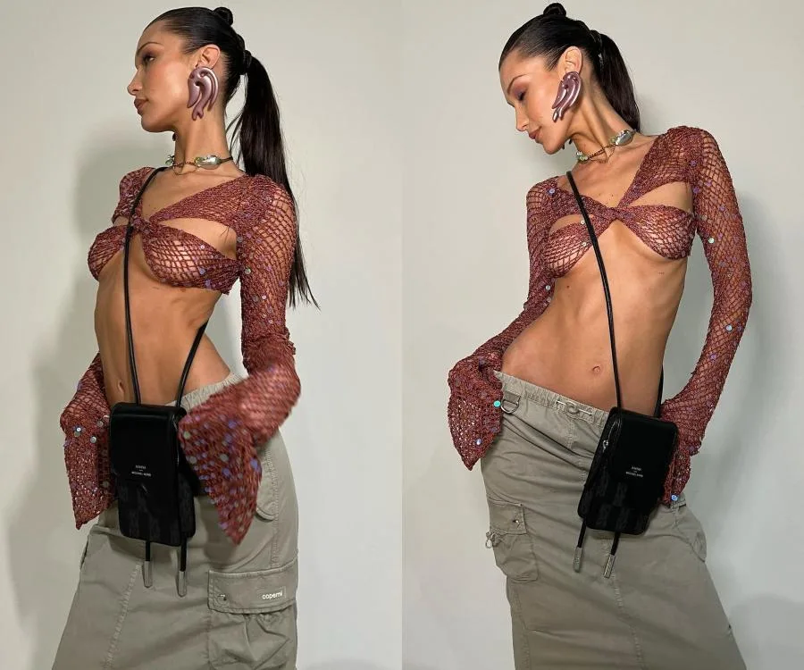 Woman in a sequined top and cargo skirt, wearing large ear-shaped earrings, poses with a crossbody bag.