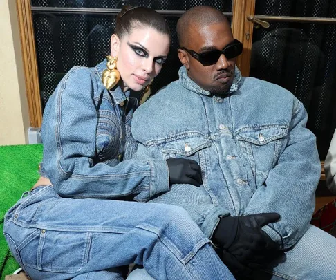 Two individuals wearing denim outfits sitting closely together on a green seat.