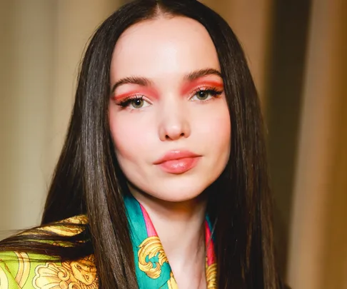 Woman with straight hair wearing red eyeliner and patterned clothing.