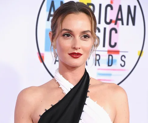 Leighton Meester at the American Music Awards, wearing a black and white dress, hair tied back, and red lipstick.