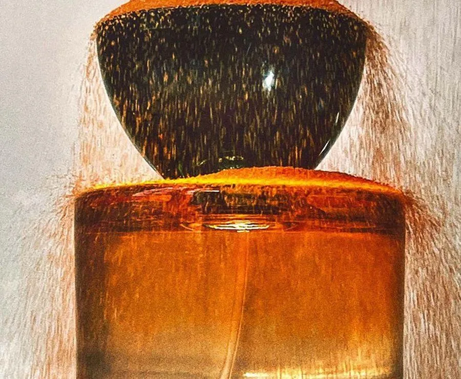 Golden-hued perfume bottles stacked, with textured surface, likely related to Vyrao fragrance collection.