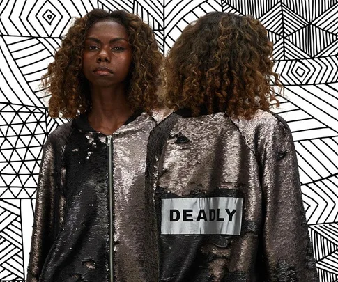 Model wearing a sequin jacket with "DEADLY" on the back, against a geometric patterned background.