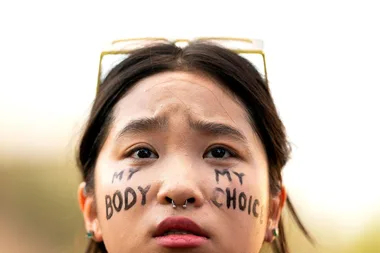 Woman with "My Body, My Choice" written on her cheeks at an abortion rights rally.