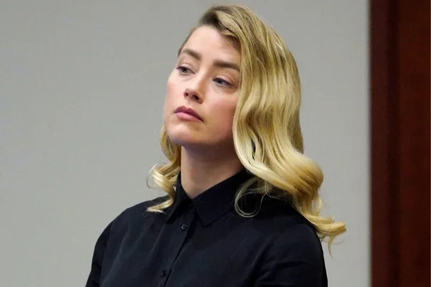 Amber Heard in courtroom during the defamation trial, looking serious and wearing a black shirt.