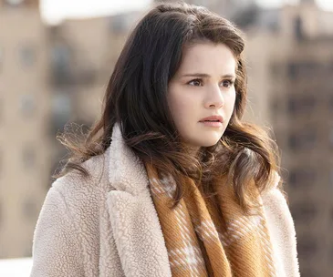 Selena Gomez as Mabel Mora in a winter coat and scarf, looking concerned, on a rooftop in "Only Murders in the Building."