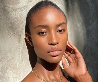 Close-up of a woman with a flawless, glowing complexion, showcasing the effects of skincare in natural light.