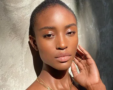 Close-up of a woman with a flawless, glowing complexion, showcasing the effects of skincare in natural light.