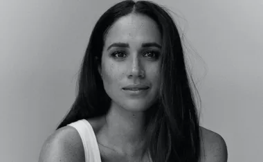 Black and white portrait of a woman with long hair, looking directly at the camera.