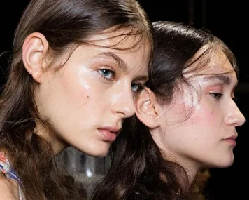 Two models with glowing skin and long hair, showcasing different jawline angles in profile.