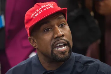 A man wearing a red "Make America Great Again" hat, speaking and looking slightly upward.