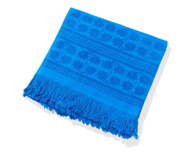 Blue beach towel with fringe and floral patterns.