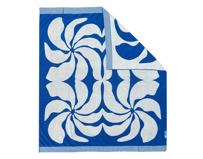 Blue beach towel with white floral patterns and striped border.