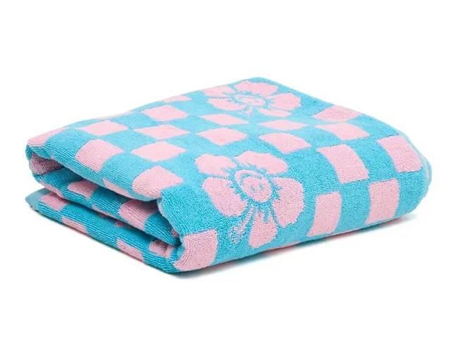 Folded blue towel with pink floral and checkered pattern.