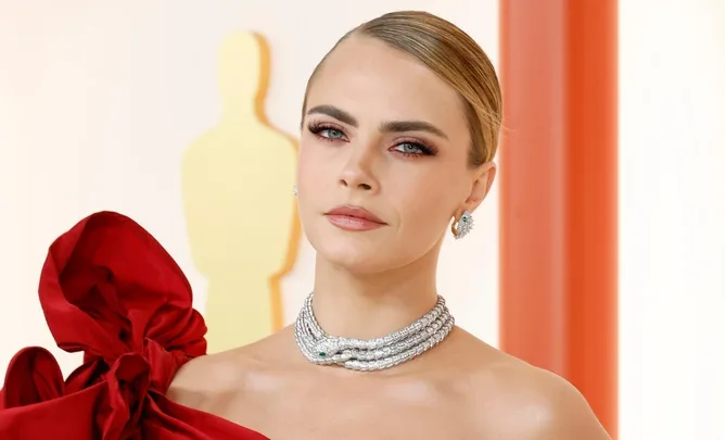 Woman in red dress with diamond necklace on Oscars 2023 red carpet.