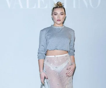 Person in a grey crop top and sheer bejeweled skirt at a Valentino event.