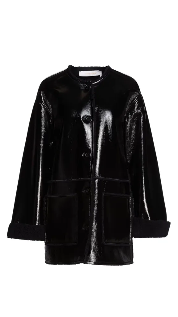 The See by Chloe Glossed Leather and Shearling Coat hits mid knee with black high shine leather exterior and internal black sheerling that peaks through the cuffs. The boxy shape is on trend and perfect for a frosty winter get away.