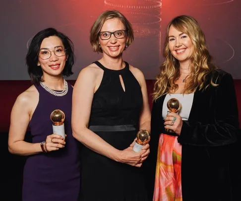 Three women holding awards at the Cartier Women's Initiative ceremony.