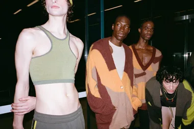 A group of models in stylish Nagnata knitwear, standing and posing indoors with a dark background.