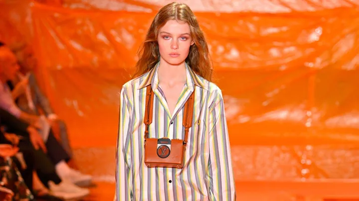 Model in a striped shirt with brown accessories on the runway at Louis Vuitton Paris Fashion Week 2024 Spring/Summer.