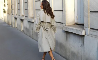 Stylish woman in a trench coat walking through Paris.