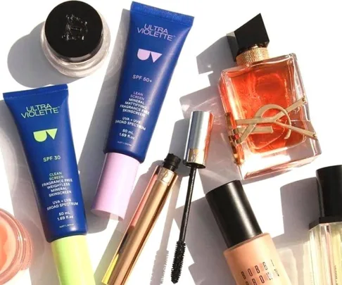 A collection of beauty products including Ultra Violette sunscreen, mascara, perfume, and Bobbi Brown foundation.