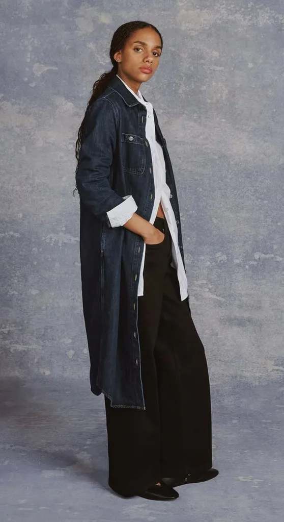 model wears black trousers and a denim coat