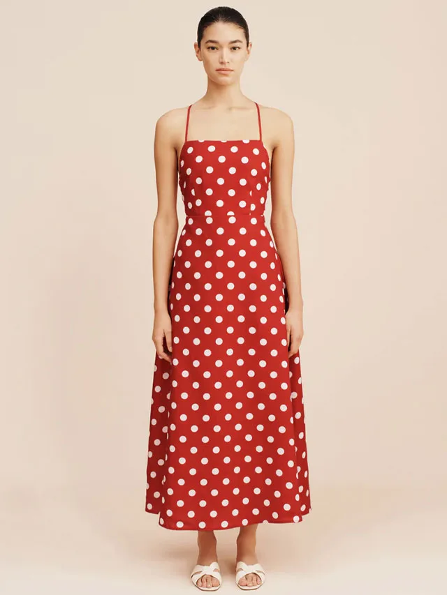 Model wears a red polka dot dress
