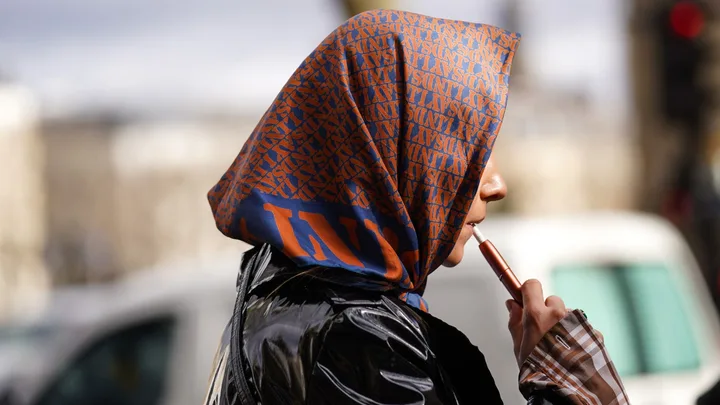 a woman vaping during paris fashion week