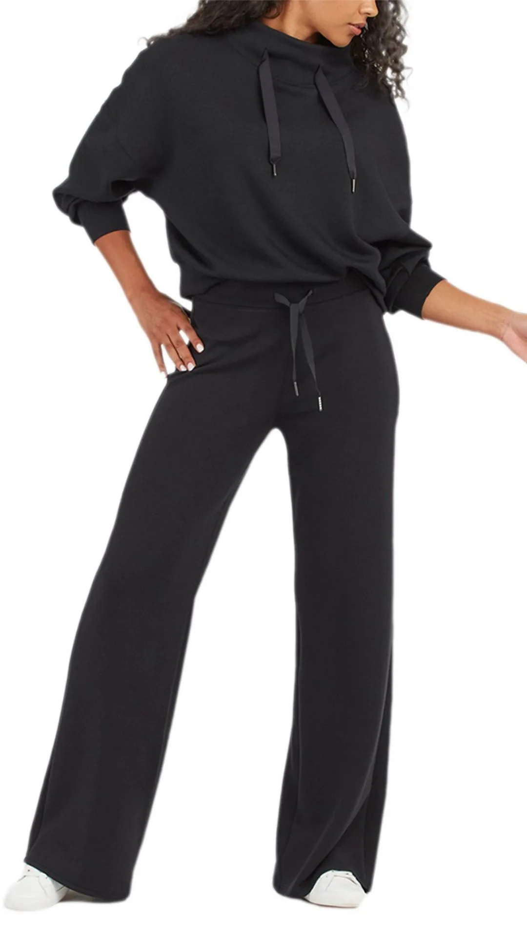 The Spanx Airluxe Wide Leg Pant uses a fine knit fabric that is lightweight and luxuriously silky on the skin while still providing warmth and optimal airflow (we all know the feeling of rugging up for a flight, only to feel weighed down and claustrophobic a few hours in). The flattering front and flared leg mean you'll be looking as well as feeling your best, and the draw cord provides a customizable fit. Worn here with white sneakers and a matching black hooded pullover.