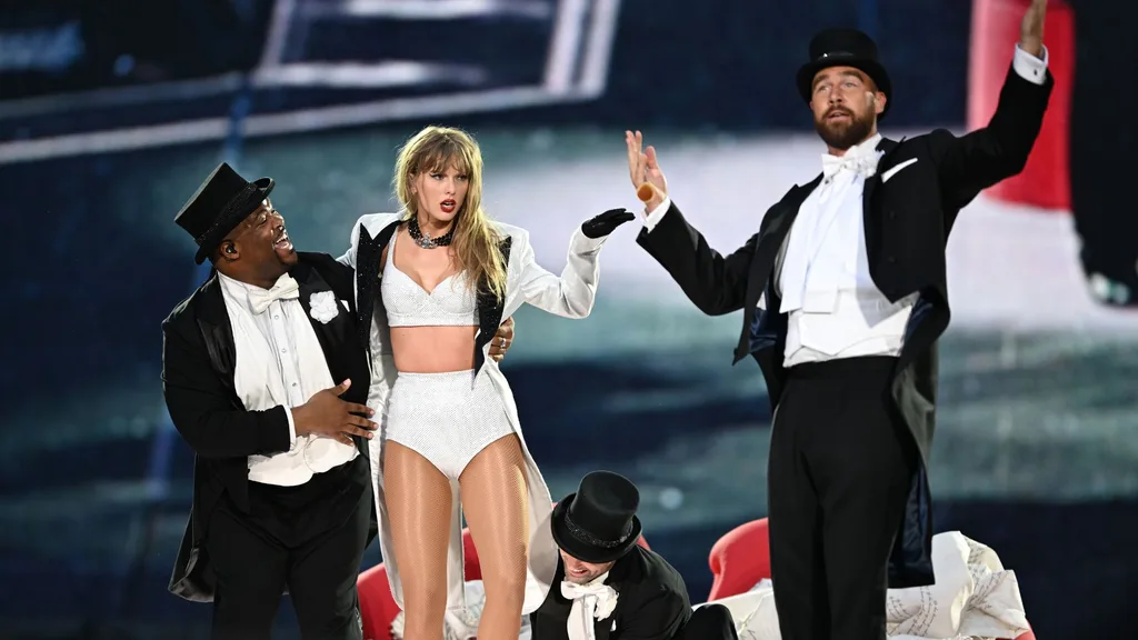 travis kelce and taylor swift on stage at eras tour