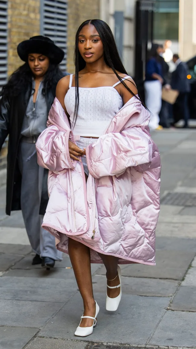 Normani wears pink puffer jacket, white top outside JW Anderson during London Fashion Week September 2024 on September 15, 2024 in London, England.