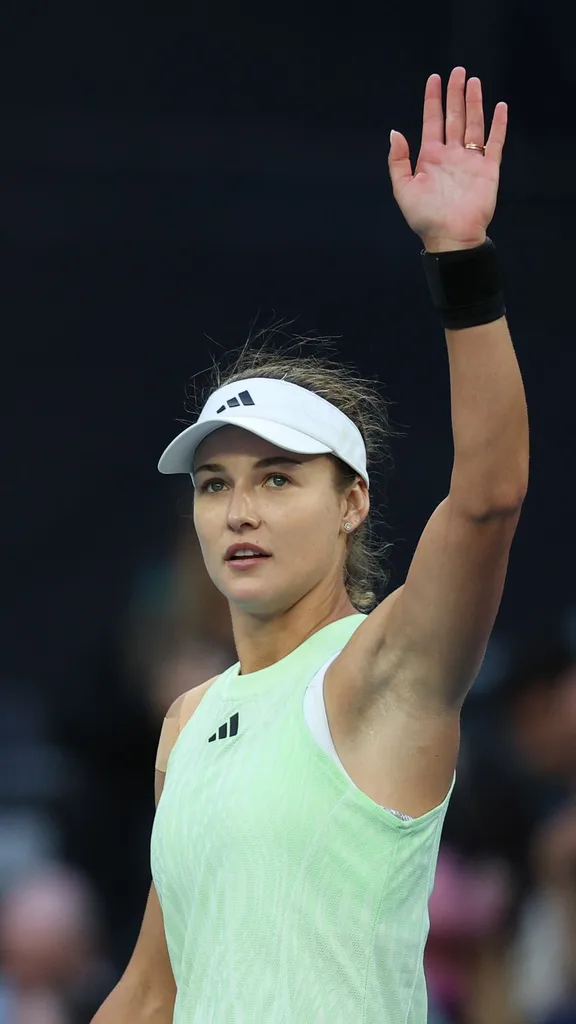 jannik sinner's girlfriend anna kalinskaya waving to fans from the tennis court