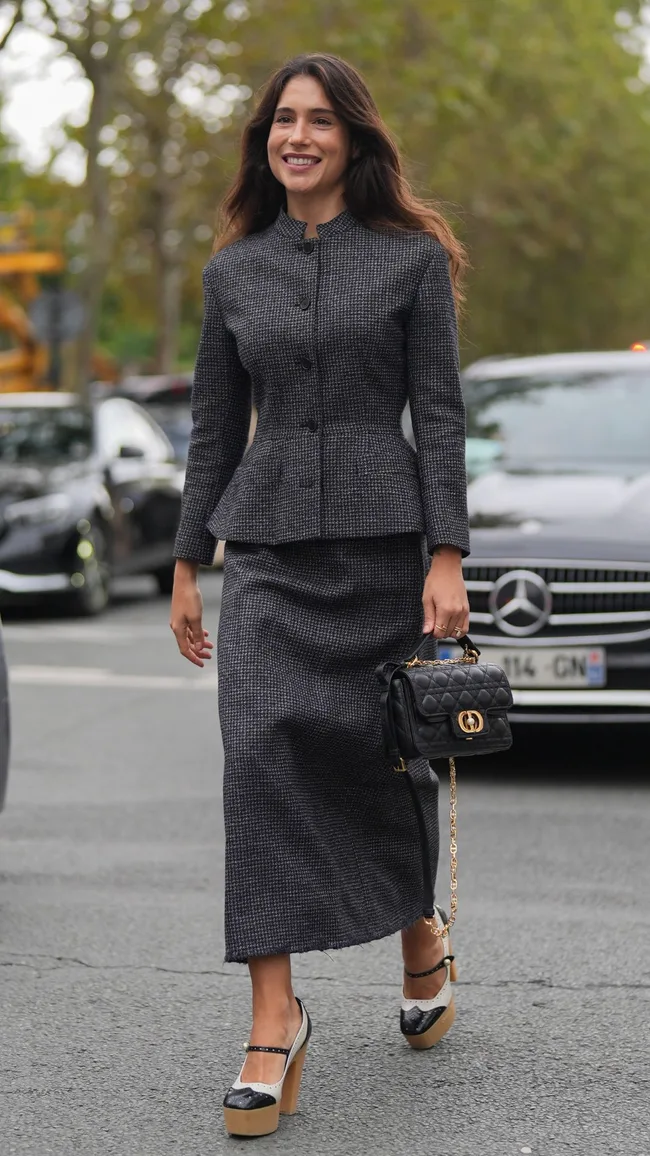 a woman wears a tailored suit to dior at paris fashion week