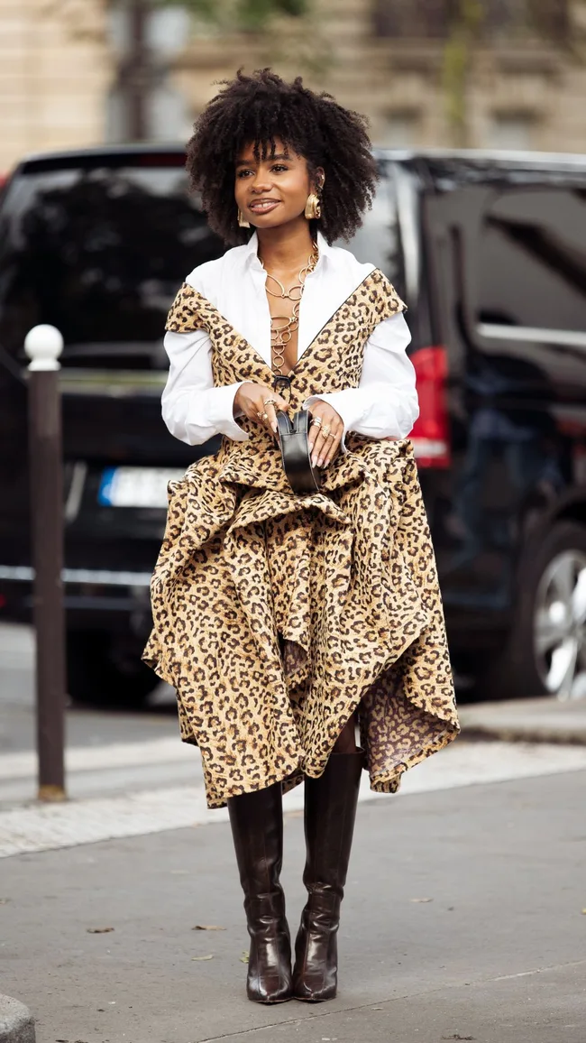 a woman wearing a leopard print dress and white collared shirt at paris fashion week