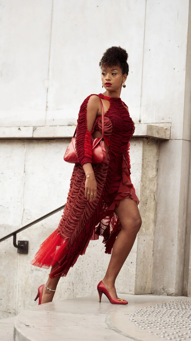 a woman at paris fashion week wearing a red dress
