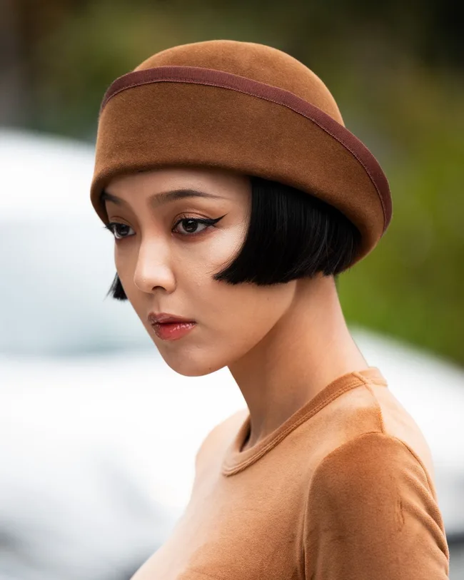 woman wears brown suede 1920s hat at paris fashion week