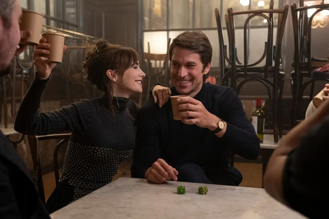 emily and gabriel laugh and drink from paper cups in Emily In Paris season four