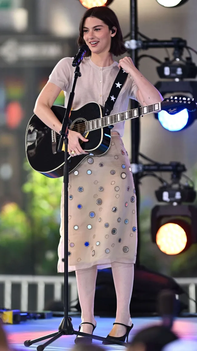 gracie abrams on stage in vintage skirt and cardigan