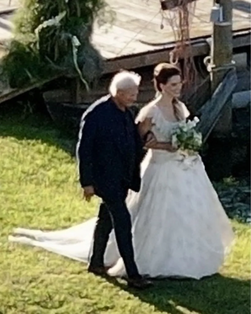 lana del rey in her white wedding dress at her outdoor wedding walking down the grass aisle with her father