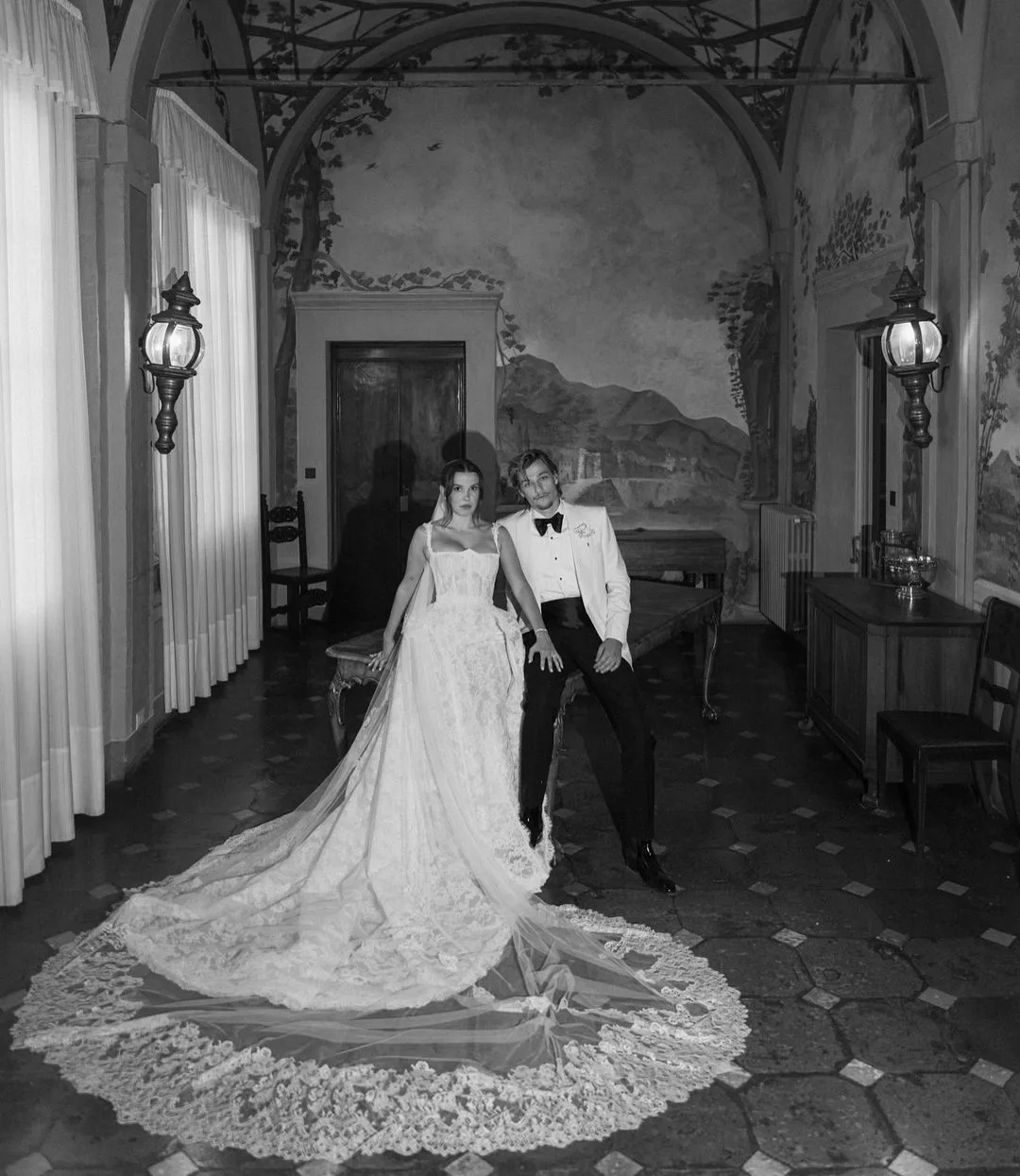 millie bobby brown in white lace wedding dress with husband jake bongiovi in white tux jacket