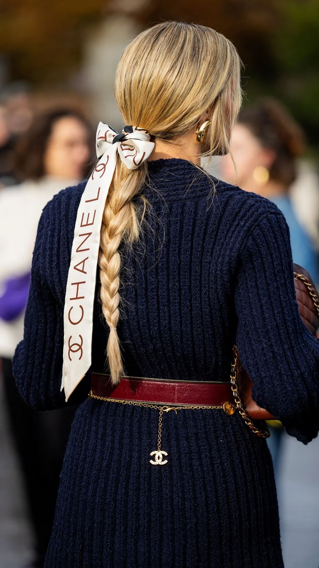 Helena Bordon wears hair band with logo navy knit, brown bag outside Chanel during Womenswear Spring/Summer 2025 as part of Paris Fashion Week on October 01, 2024 in Paris, France.