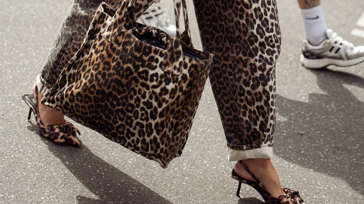 A guest wears animal print pants, animal print jacket and animal print bag outside the Gestuz show during day four of the Copenhagen Fashion Week