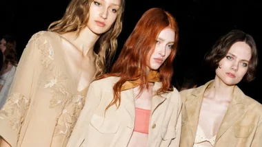 Three woman with wavy hair backstage at Milan Fashion Week