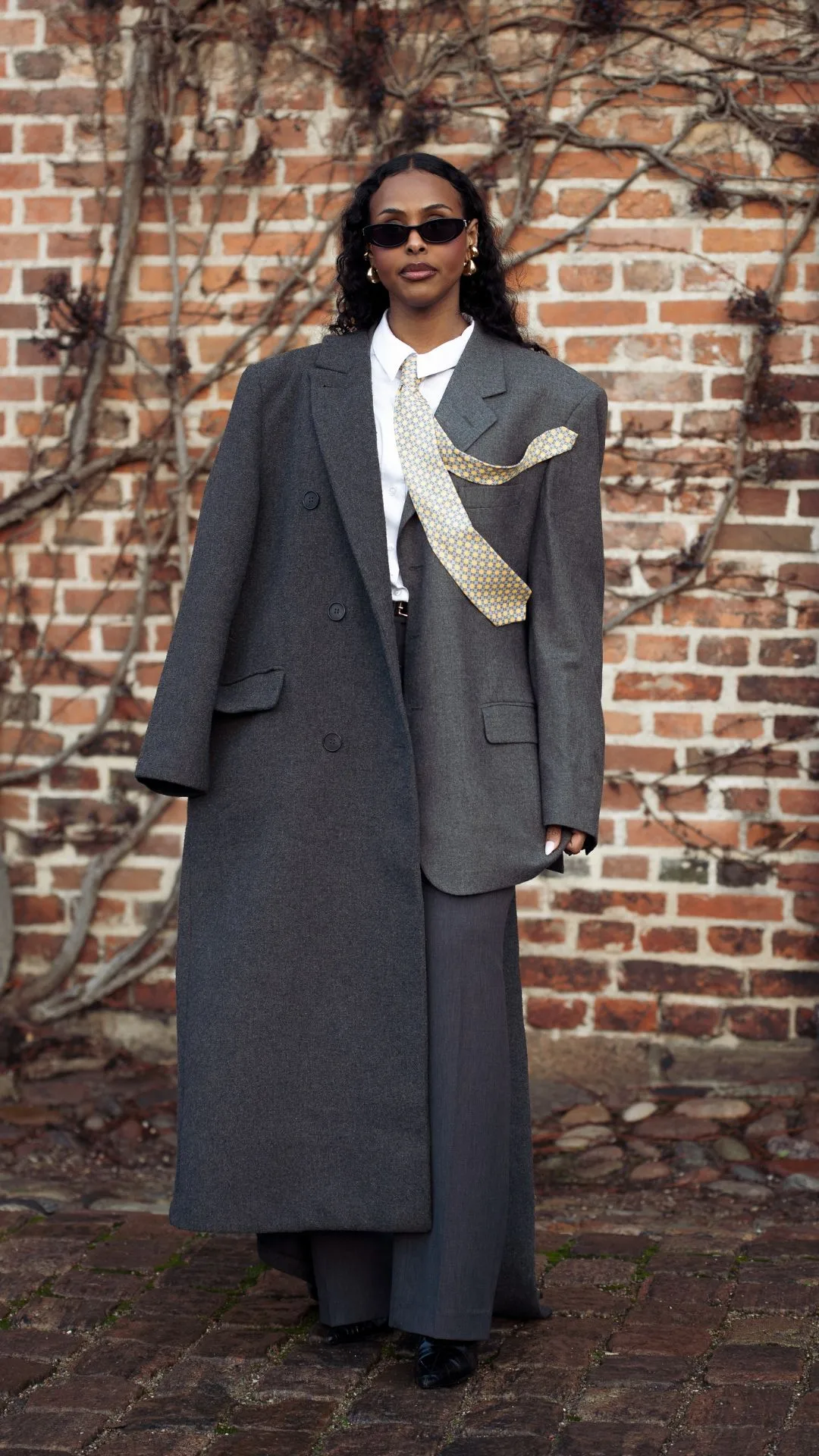 copenhagen street style fashion week autumn winter 2025 woman wears grey suit, coat and tie