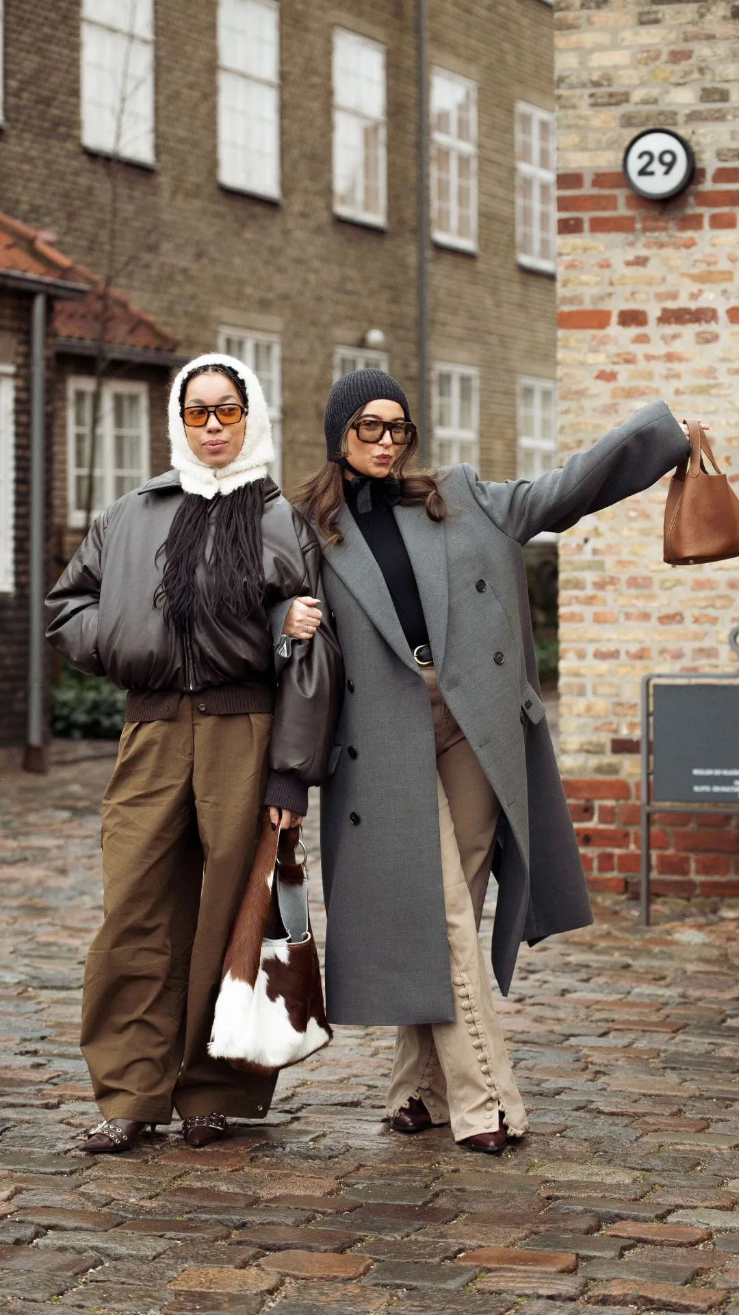 copenhagen street style fashion week autumn winter 2025 two women playfully pose for the camera