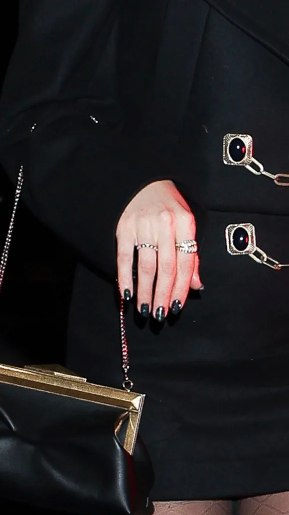 A close up of Taylor Swift's infinity ring which features a thick gold band studded with diamonds