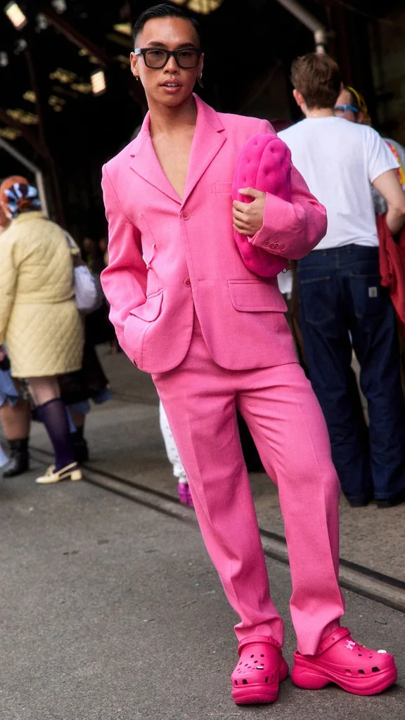 Street style person in pink suit and pink croc clogs at Australian Fashion Week