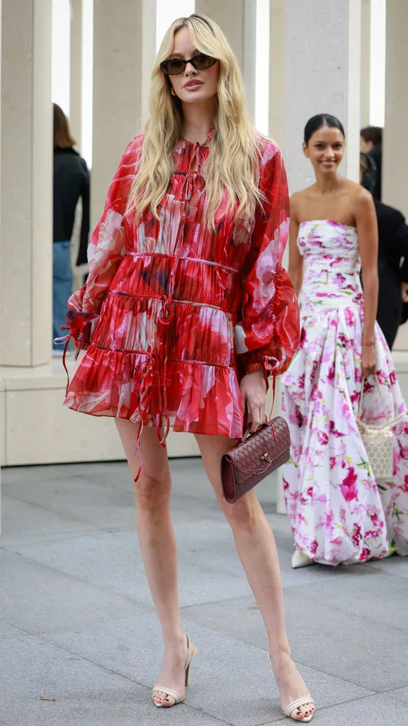 A guest at Australian fashion week wearing a floaty red mini dress with beige heels